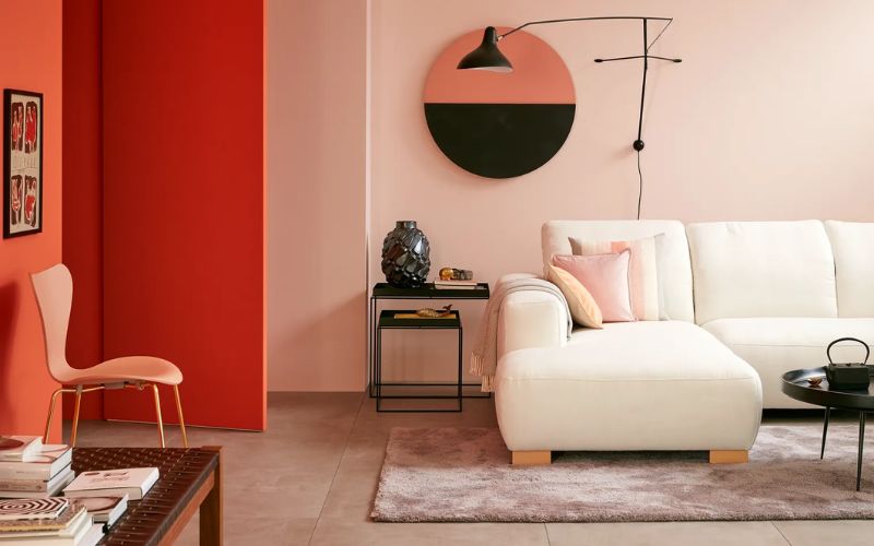 Không gian phòng khách với màu hồng pastel chủ đạo, cam nhấn điểm